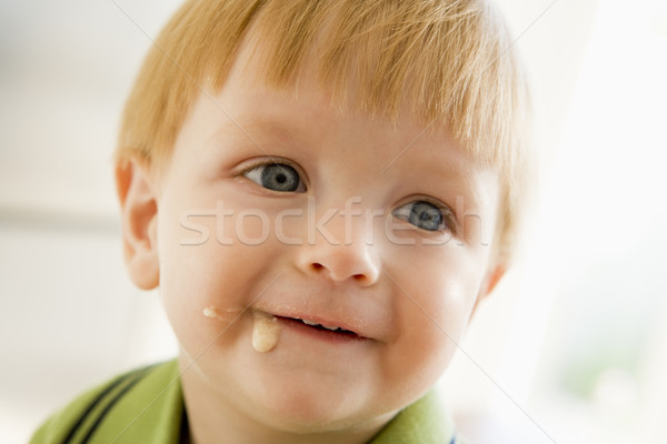 Young boy eating baby food with mess on face Stock photo © monkey_business