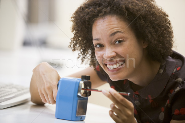 Woman in computer room using pencil sharpener and smiling Stock photo © monkey_business