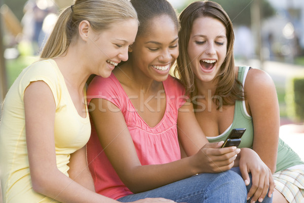 Tinilányok ül kívül játszik mobiltelefon barátok Stock fotó © monkey_business