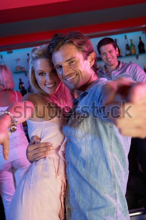 Stock photo: Senior Man Dancing With Younger Woman In Busy Bar