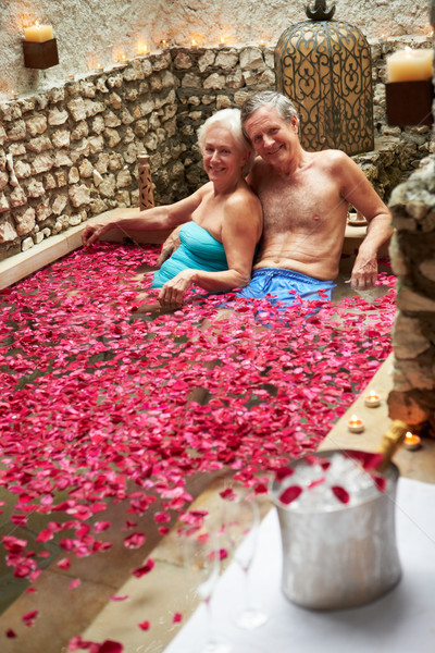 Senior Couple Relaxing In Flower Petal Covered Pool At Spa Stock photo © monkey_business