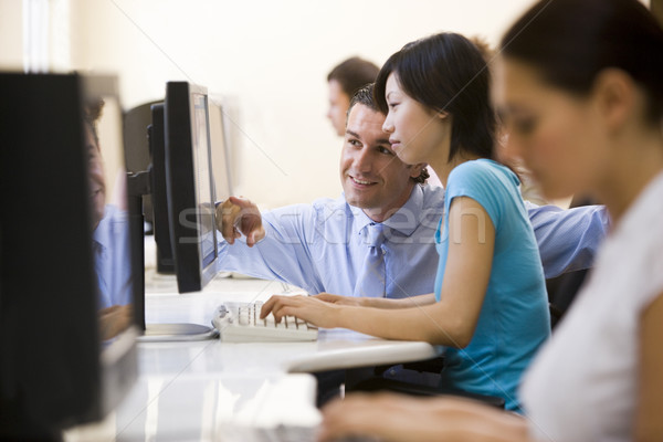 Man assisting woman in computer room smiling Stock photo © monkey_business