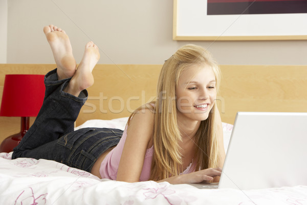 Folosind laptop dormitor faţă laptop tehnologie Imagine de stoc © monkey_business