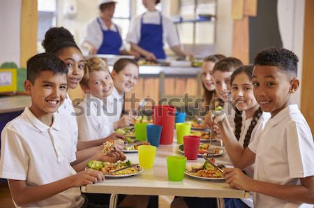 A teacher eating lunch with his students in the school cafeteria Stock photo © monkey_business