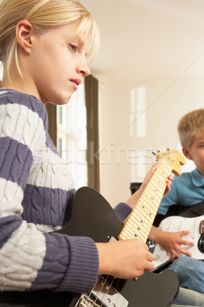 Stock photo: Boy and girl playing electric guitars at home