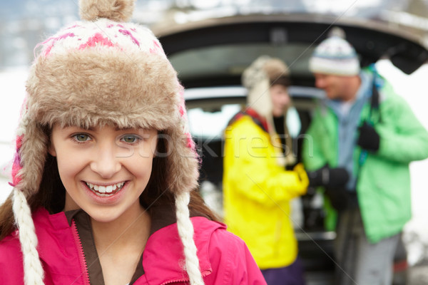 Teenage Girl Smiling At Camera Whilst Family Load Skis In Boot O Stock photo © monkey_business