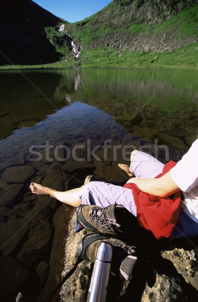 Young woman relaxing on rocks next to lake Stock photo © monkey_business