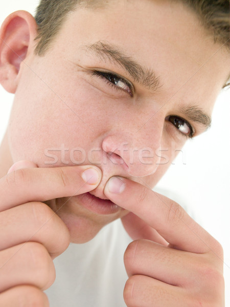 Teenage boy popping zit on face Stock photo © monkey_business