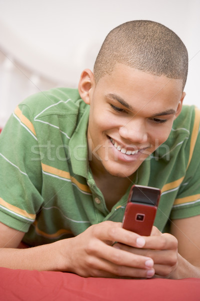 Tizenéves fiú ágy mobiltelefon otthon technológia fiú Stock fotó © monkey_business