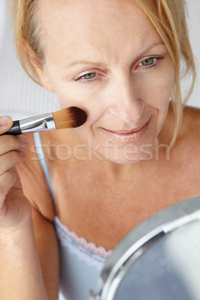 Mid age woman putting on make-up Stock photo © monkey_business