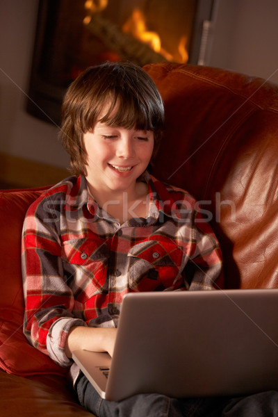 Young Boy Relaxing With Laptop By Cosy Log Fire Stock photo © monkey_business