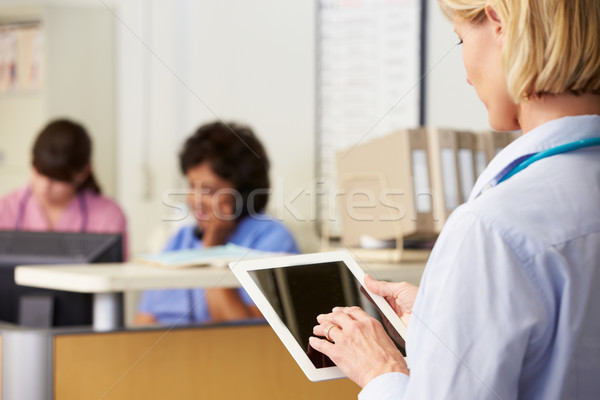 Stock photo: Female Doctor Using Digital Tablet At Nurses Station