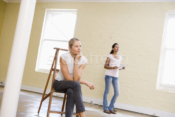 Two women with ladder in empty space holding paper Stock photo © monkey_business