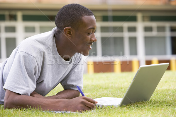 Főiskolai hallgató laptopot használ kampusz gyep számítógép férfi Stock fotó © monkey_business