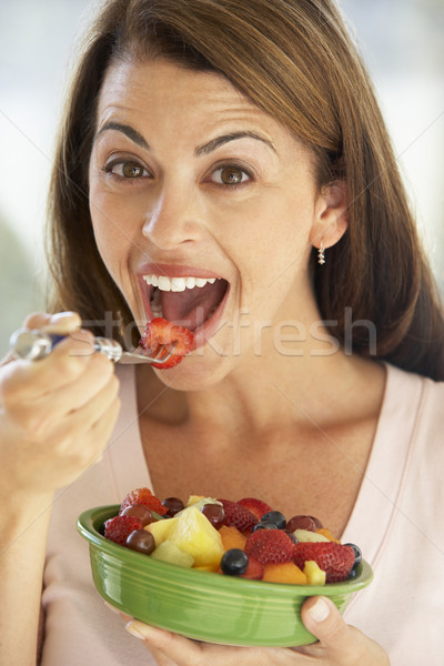 Adulte femme manger fruits frais salade maison [[stock_photo]] © monkey_business