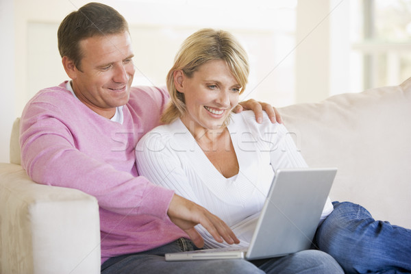 Couple in living room using laptop and smiling Stock photo © monkey_business