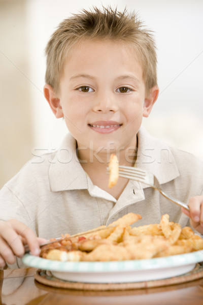 Young boy indoors eating fish and chips smiling Stock photo © monkey_business