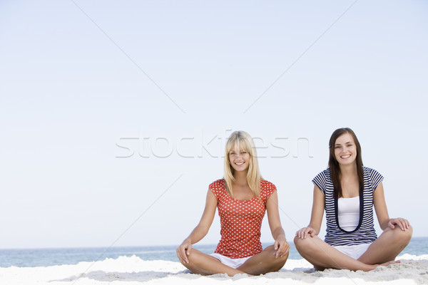 Dos mujeres sesión playa océano detrás mujeres Foto stock © monkey_business