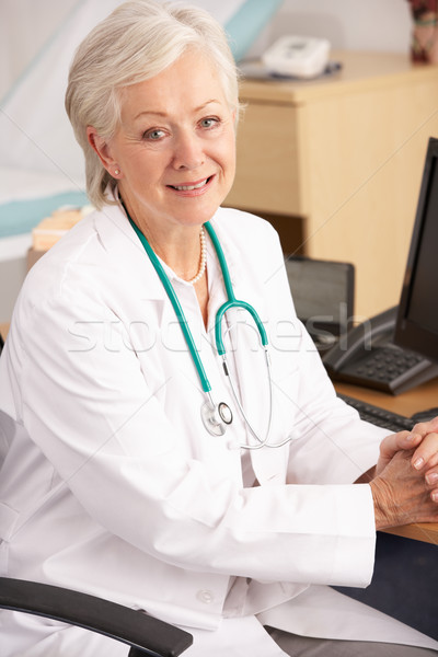 American female doctor sitting at desk Stock photo © monkey_business