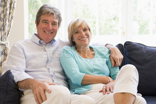 Couple relaxing in living room smiling Stock photo © monkey_business