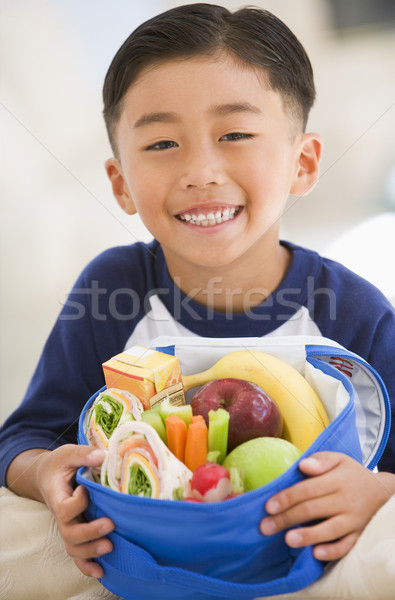 Young boy indoors with packed lunch smiling Stock photo © monkey_business