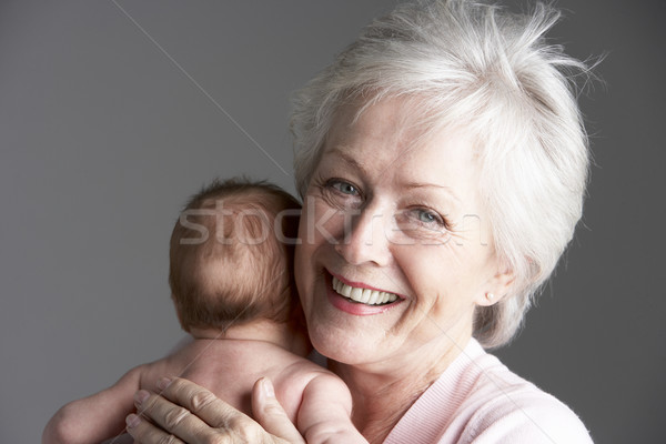 Stock photo: Studio Shot Of Grandmother Cuddling Granddaughter