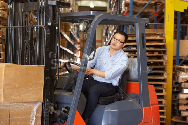Man Driving Fork Lift Truck In Warehouse Stock photo © monkey_business