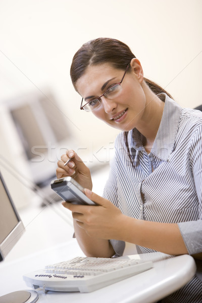Woman in computer room using personal digital assistant and smil Stock photo © monkey_business