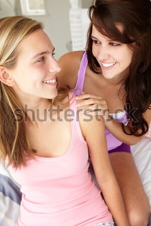 Two young women enjoying a tea party while one sits apart wearin Stock photo © monkey_business