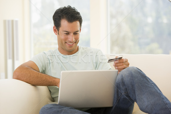 Człowiek salon za pomocą laptopa karty kredytowej uśmiechnięty Zdjęcia stock © monkey_business