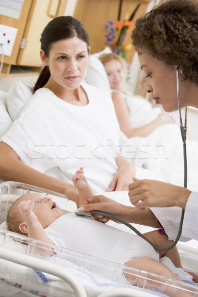 Doctor checking baby's heartbeat with new mother watching Stock photo © monkey_business