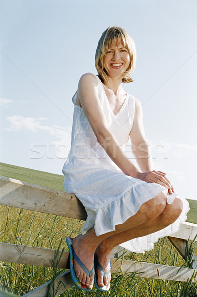 Foto stock: Mulher · sessão · cerca · ao · ar · livre · sorrindo · sorridente