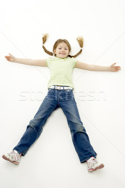 Studio Portrait of Smiling Girl lying down with arms and legs sp Stock photo © monkey_business