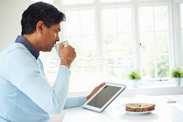 Indiai férfi digitális tabletta eszik reggeli Stock fotó © monkey_business