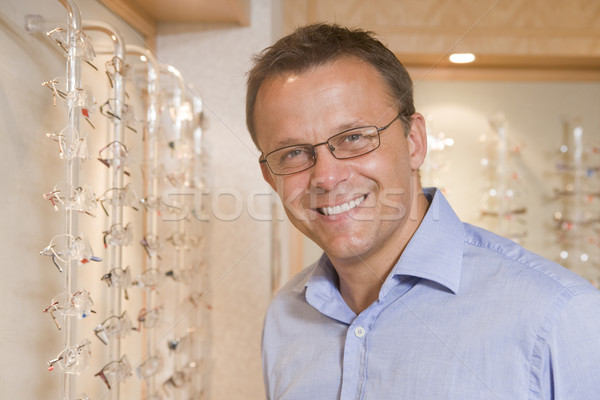 Man trying on eyeglasses at optometrists smiling Stock photo © monkey_business