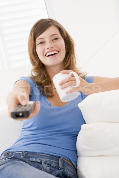 Сток-фото: женщину · гостиной · пультом · кофе · улыбающаяся · женщина · улыбаясь