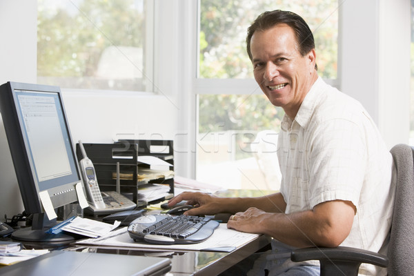 Man in home office at computer smiling Stock photo © monkey_business