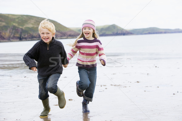 Dois jovem crianças corrida praia de mãos dadas Foto stock © monkey_business