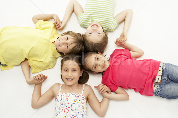 Circle of four young friends smiling and holding hands Stock photo © monkey_business