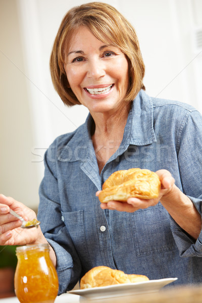 Mid age woman eating croissants Stock photo © monkey_business