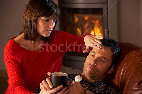 Wife Nursing Sick Husband With Cold Resting On Sofa By Cosy Log  Stock photo © monkey_business