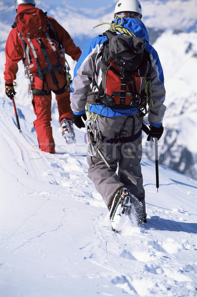 Young men mountain climbing on snowy peak Stock photo © monkey_business