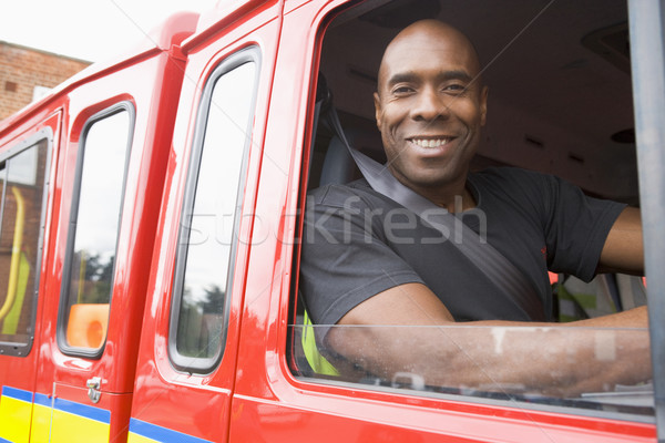 Male firefighter sitting in the cab of a fire engine Stock photo © monkey_business