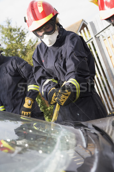 Firefighters breaking a car windscreen to help a car crash victi Stock photo © monkey_business