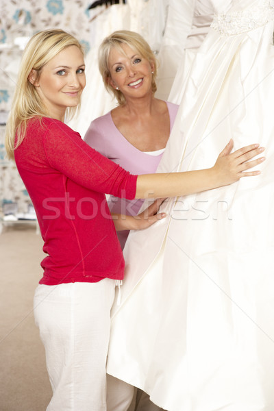 Stock photo: Bride trying on wedding dress with sales assistant