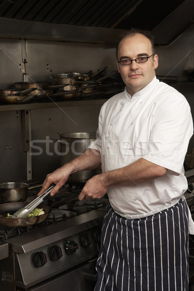 Male Chef Preparing Meal On Cooker In Restaurant Kitchen Stock photo © monkey_business