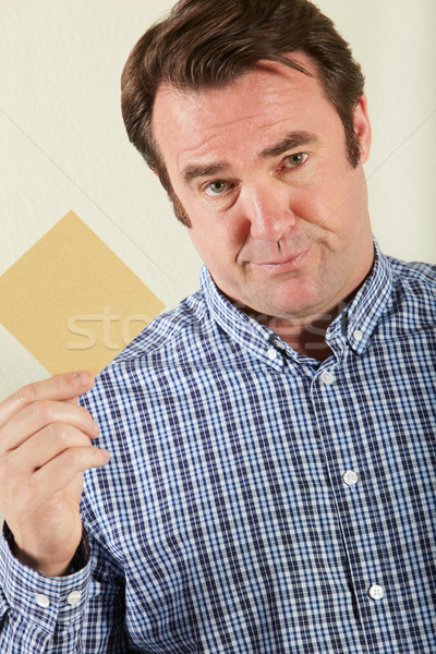 Stock photo: Studio Shot Of Middle Aged Man Holding Wage Packet