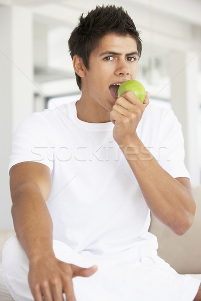 Tânăr mananca verde măr om fruct Imagine de stoc © monkey_business