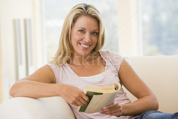 Stock photo: Woman in living room reading book smiling