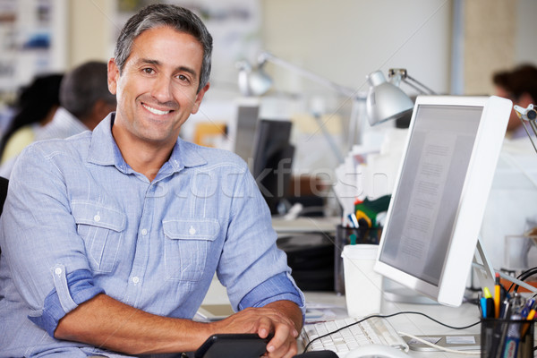 Man Working At Desk In Busy Creative Office Stock Photo C Monkey